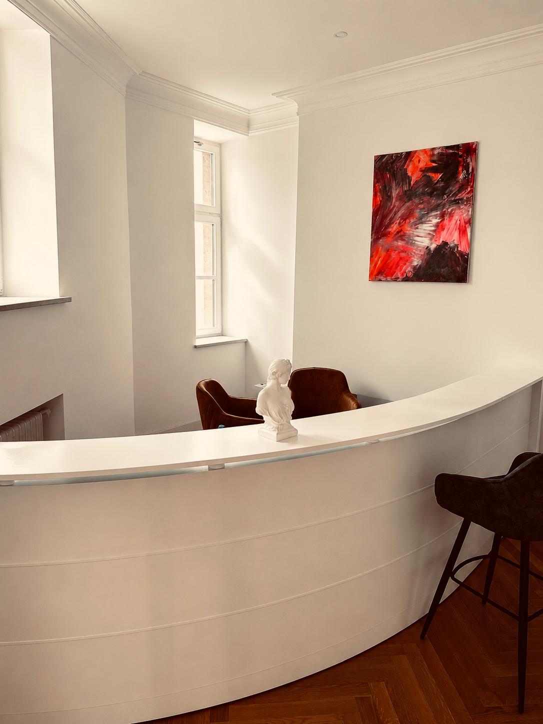 Empfangstheke mit Büste und modernem Kunstwerk im Altbau am Platzl